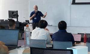 Meeting Room:  Speakers in front of attendees, slides behind speakers 